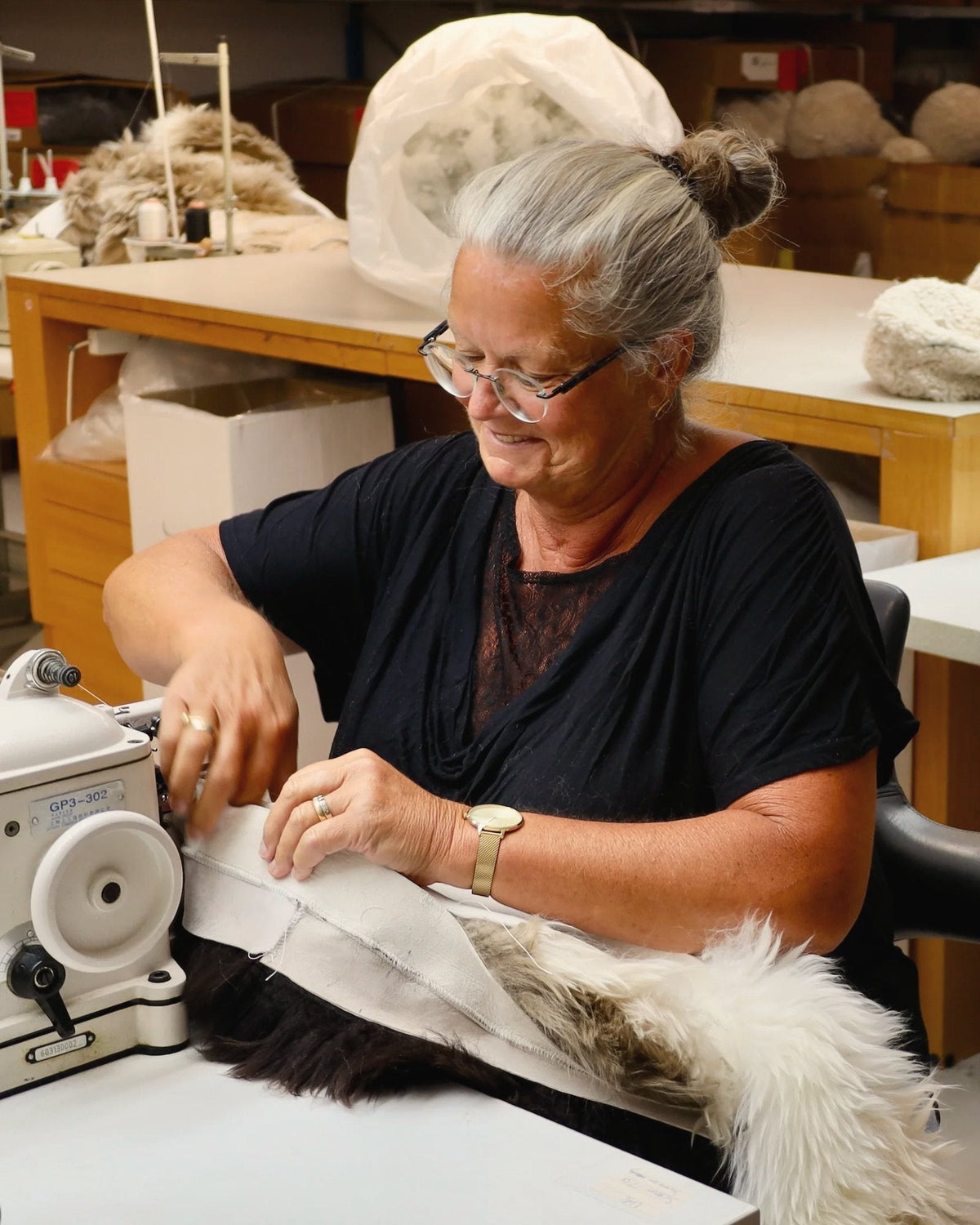 A seamstress in our studio sewing sheepskins together on a fur sewing machine